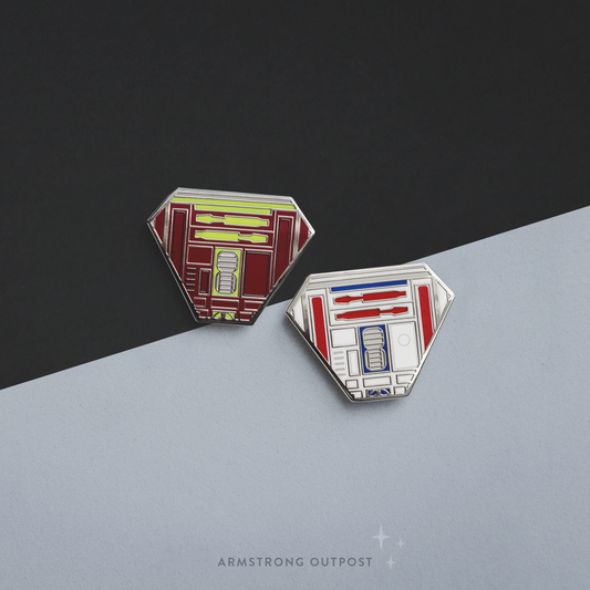 Two enamel pins on a black and gray gradient background with 'Armstrong Outpost' branding.